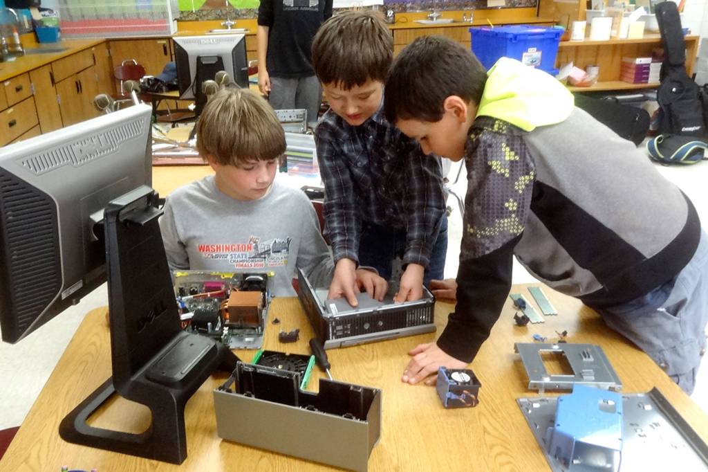 Zephyr Thompson, Aiden Johnson and Andre Campbell work together to rebuild a computer during Roosevelt Elementarys Computer Club. Photo courtesy of Dick Wolf