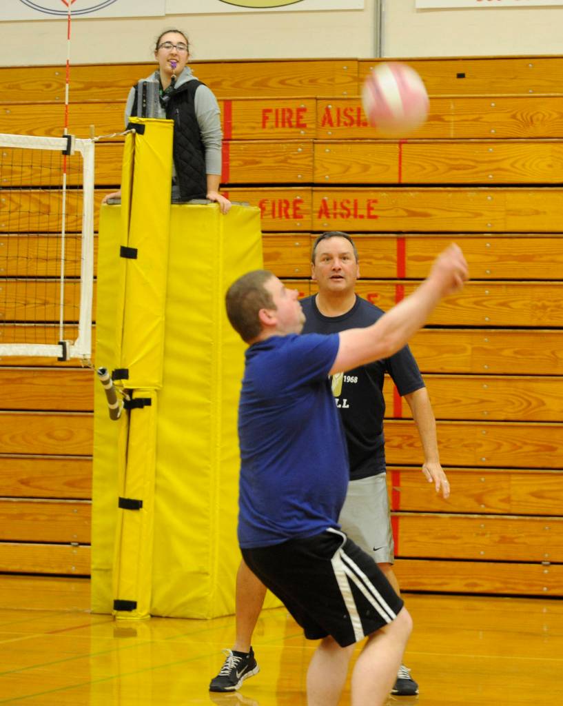 As Sequim High principal Shawn Langston looks on, teacher Jorn VandeWeghe goes no-look on his hit over the net at last weeks inter-school rivalry game. Officiating is Lillian Ode, a Sequim High graduate and volleyball coach. Sequim Gazette photo by Michael Dashiell