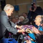 Retired U.S. Navy Rear Adm. James Kelly presents World War II veteran Roy Ellefson, who served in the Army Air Corps, with a blanket during the Veterans Day ceremony at U.S. Coast Guard Air Station/Sector Field Office Port Angeles on Sunday. (Jesse Major/Peninsula Daily News)