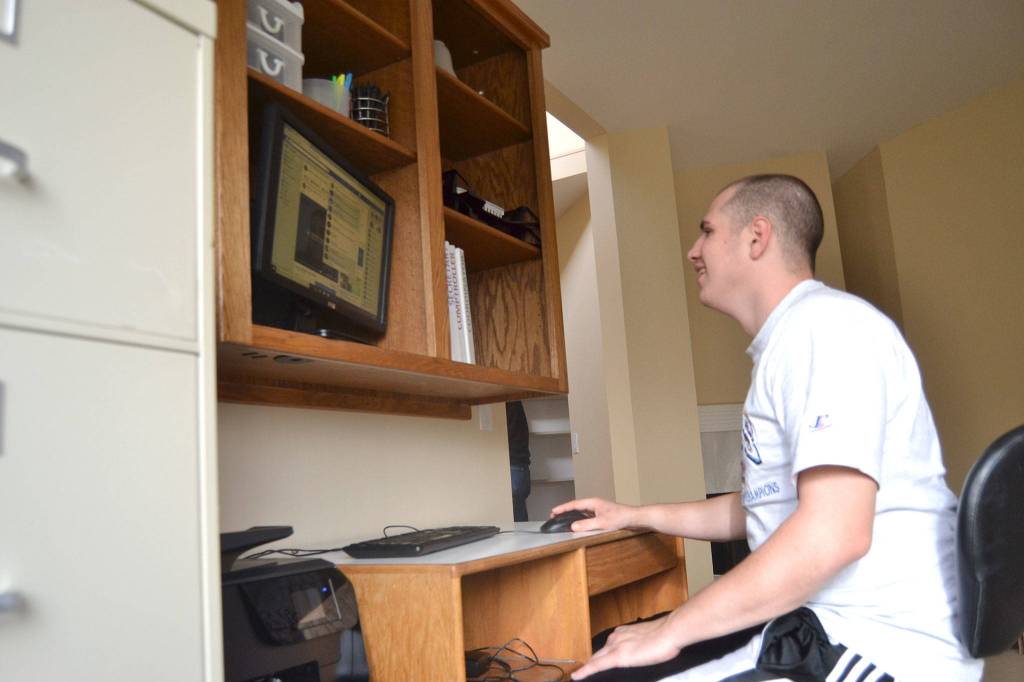 Gavin Clough checks his Facebook page inside the Oxford House Rainshadow.