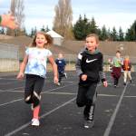 Anella Henning and Carson Olsen run to a stop so their laps at Helen Haller Elementarys Turkey Trot fundraiser can be counted. Sequim Gazette photo by Matthew Nash