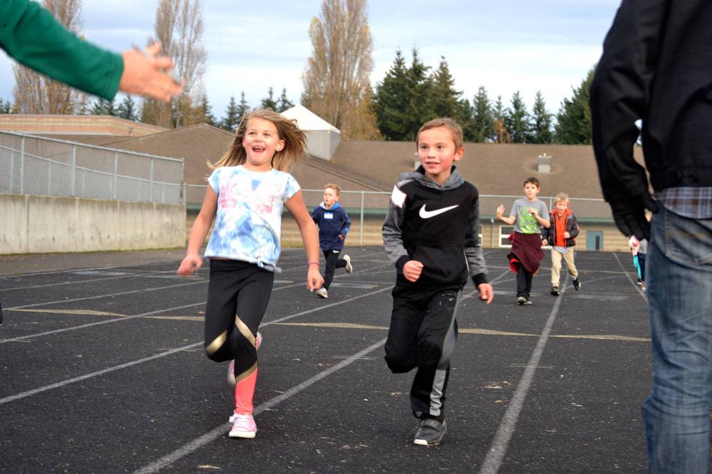 Anella Henning and Carson Olsen run to a stop so their laps at Helen Haller Elementarys Turkey Trot fundraiser can be counted. Sequim Gazette photo by Matthew Nash