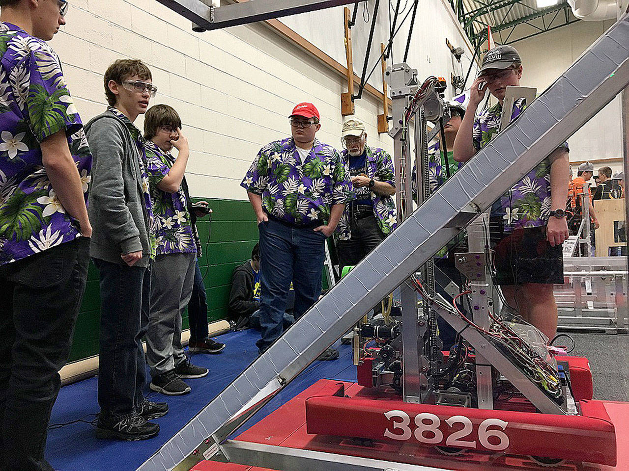 Sequim Robotics Federation team members gather around for a weigh-in of their robot last year in Yakima. This year, the team hosts a fundraiser on Dec. 1 at Sequim High School with a luau and auctions. Submitted photo