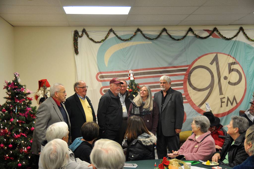 Board members for Sequim Community Broadcasting, the non-profit parent company of KSQM 91.5 FM, greet the audience inside the stations new community room on Dec. 7 during its annual open house. Standing from left, are James Hindes, Al Friess, George Dooley, president, Scott Scherer, Lynda Perry and Jeff Bankston. Sequim Gazette photo by Matthew Nash