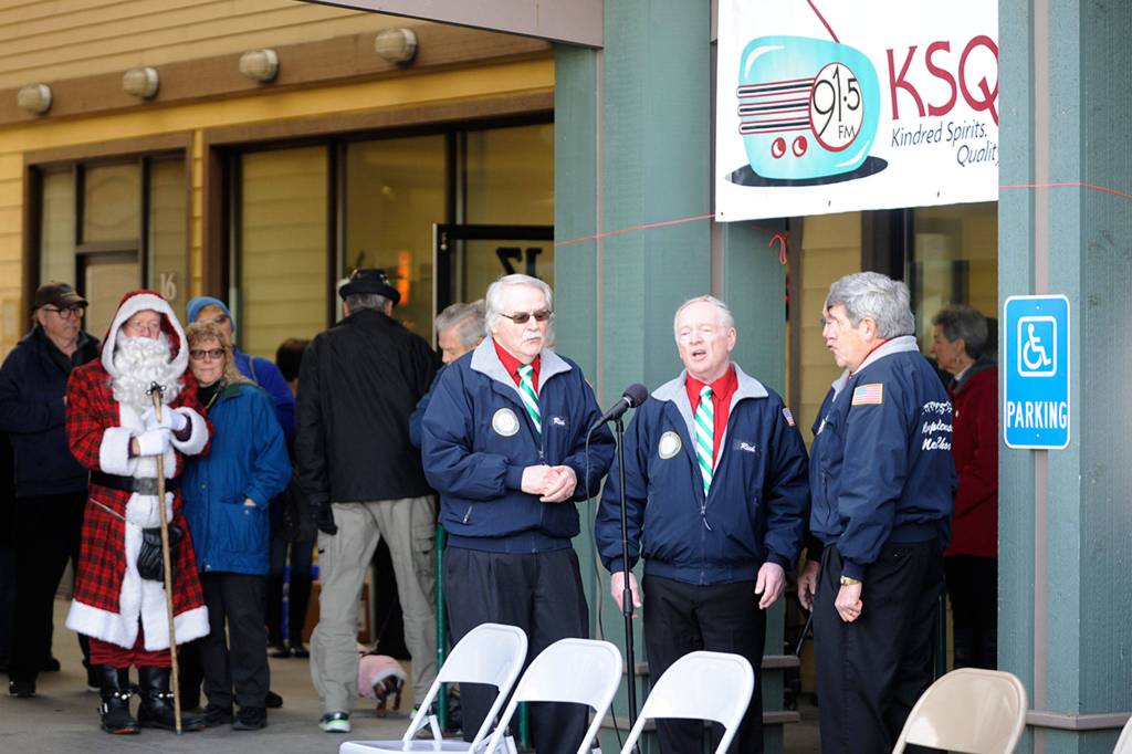 No Batteries Required sing for a crowd at KSQMs ribbon cutting on Dec. 7 as Santa Claus listens in. Sequim Gazette photo by Matthew Nash