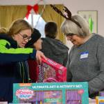 Danielle Schleve of Sequim looks for presents for her six children with help from Chris Barton at the annual Toys for Sequim Kids event on Dec. 12. See story on Page 12. Sequim Gazette photo by Matthew Nash