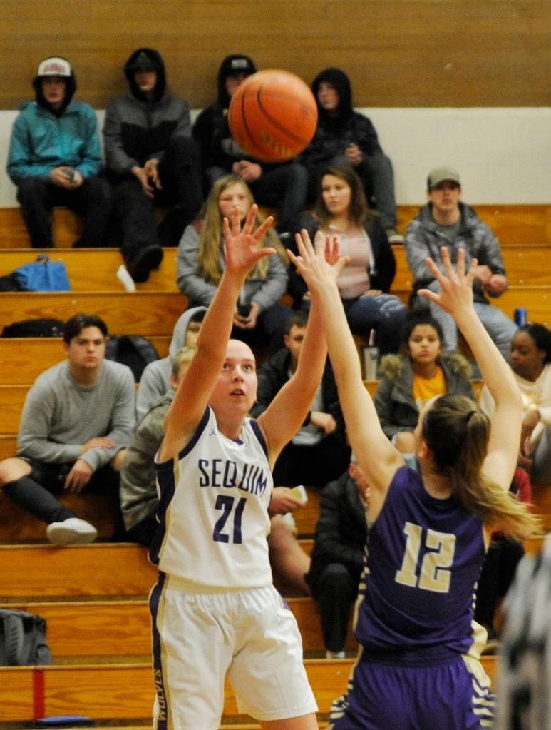 Sequims Kalli Wiker (21) puts up a shot over North Kitsap forward Grace Johnson in the second half of the Wolves 61-53 loss on Dec. 18. Wiker led Sequim with 17 points. Sequim Gazette photo by Michael Dashiell
