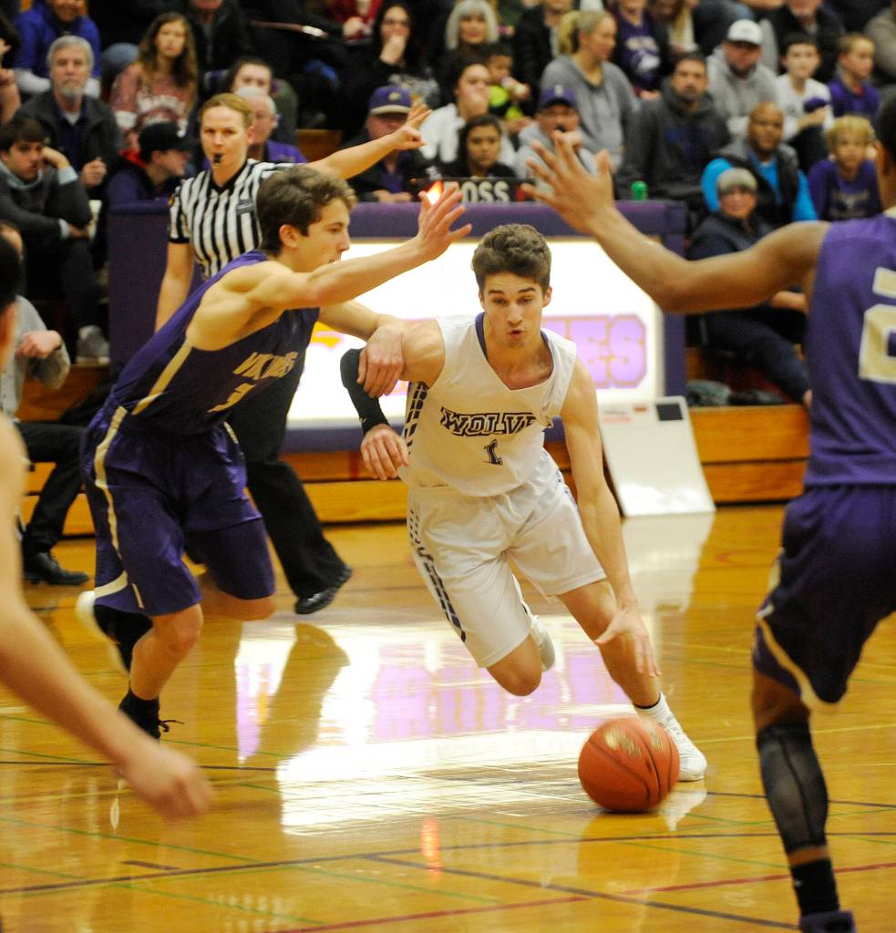 Sequim guard Nate Despain, center, looks for room to drive in a Dec. 18 Olympic League match-up against North Kitsap. Despite Despains 20 points, NK won the game 70-55. Sequim Gazette photo by Michael Dashiell