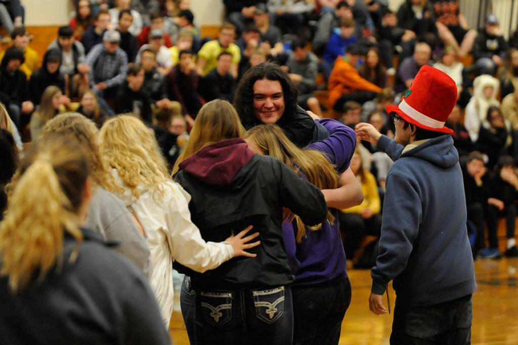 Brandon Adams receives a big hug from fellow members of the Sequim FFA on Dec. 19. The club worked together to pay for an official FFA sweatshirt for him for the Winter Wishes assembly. Sequim Gazette photo by Matthew Nash