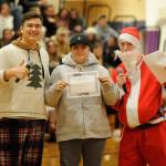 Chris Buckla, center, receives free drivers education courses during the Winter Wishes assembly presented by Tommy Hall and Jarrett Allen. Sequim Gazette photo by Matthew Nash