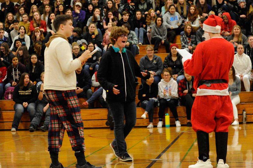 Sequim sophomore Anna Fankhouser receives a PlayStation 3 and a few video games for her wish from Tommy Hall, left, and Jarrett Allen. She said her first thoughts were a mix of happy and is this real? Sequim Gazette photo by Matthew Nash