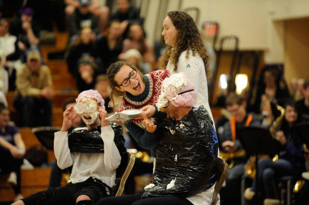 Students Maggie van Dyken, second from left, and Arlene Law put pies in Teacher Isaac Rapelje and Student Isabelle Hugoniots faces during the Winter Wishes assembly. In October, students won a contest for earning the most for breast cancer research and selected Rapelje to receive the pie. Hugoniot participated for fun. Sequim Gazette photo by Matthew Nash