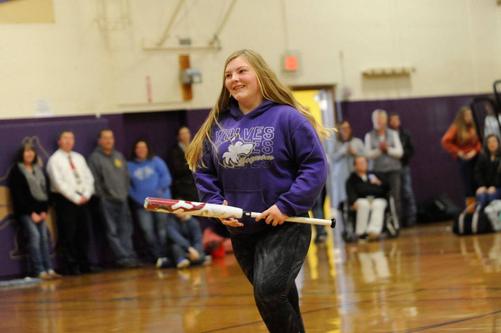 Victoria Lelle smiles as she walks from center court after receiving a baseball bat during the Winter Wishes assembly. Lelle said she didnt think shed get the bat. This school is really good about helping people get what they want. Im really grateful for it, she said.