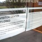 Signs on the front door of the Olympic National Park visitor center in Port Angeles explain that the park will not provide services for the duration of the government shutdown and that visitors to the park do so at their own risk. (Keith Thorpe/Peninsula Daily News)