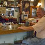 Larry Culp, co-owner of Old Mill Cafe and a Carlsborg resident since 1957, sits in his restaurant by the Carlsborg Mills original sign that sits over the bar. As far as how to say Carlsborg, Culp says -Borg. A lot of people say -Berg. I think its -Borg, he said. Sequim Gazette photos by Matthew Nash