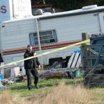 Investigators document the crime scene at a property on Bear Meadow Road where three bodies have been found. (Jesse Major/Peninsula Daily News)
