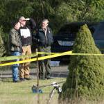 Clallam County Prosecuting Attorney Mark Nichols, left, talks with Clallam County Sheriff Bill Benedict on Tuesday at the scene of several deaths. (Jesse Major/Peninsula Daily News)