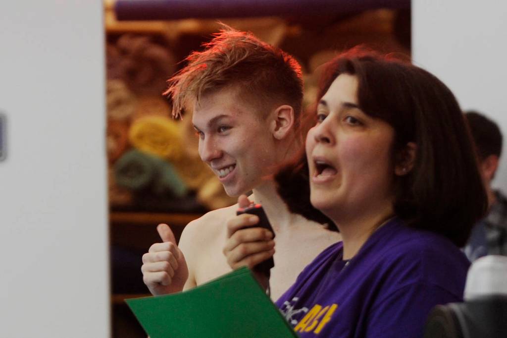 Alex Berikoff joins fellow seniors in receiving some accolades and gifts from coach Anita Benitez on Jan. 24, the Wolves final home meet of the 2018-2019 season. Sequim Gazette photo by Michael Dashiell