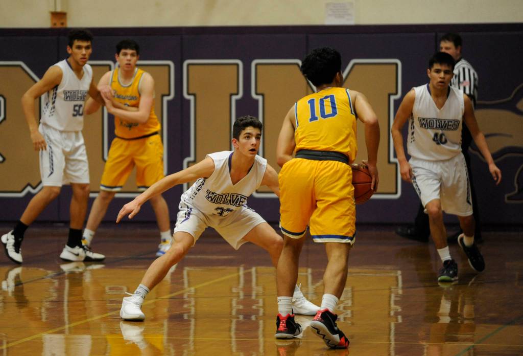 Dallin Despain, center, keeps a close eye on Bremertons Keoni Laguana in the first half of a 12-point Sequim win on Jan. 18. Sequim Gazette photo by Michael Dashiell