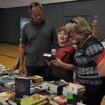 The Bowden family looks at Jonathans new book he received from Sequims Back to School Fair provided by the Clallam County Literacy Council. Volunteers setup at close to a dozen events like this each year to promote reading. Sequim Gazette file photo by Michael Dashiell