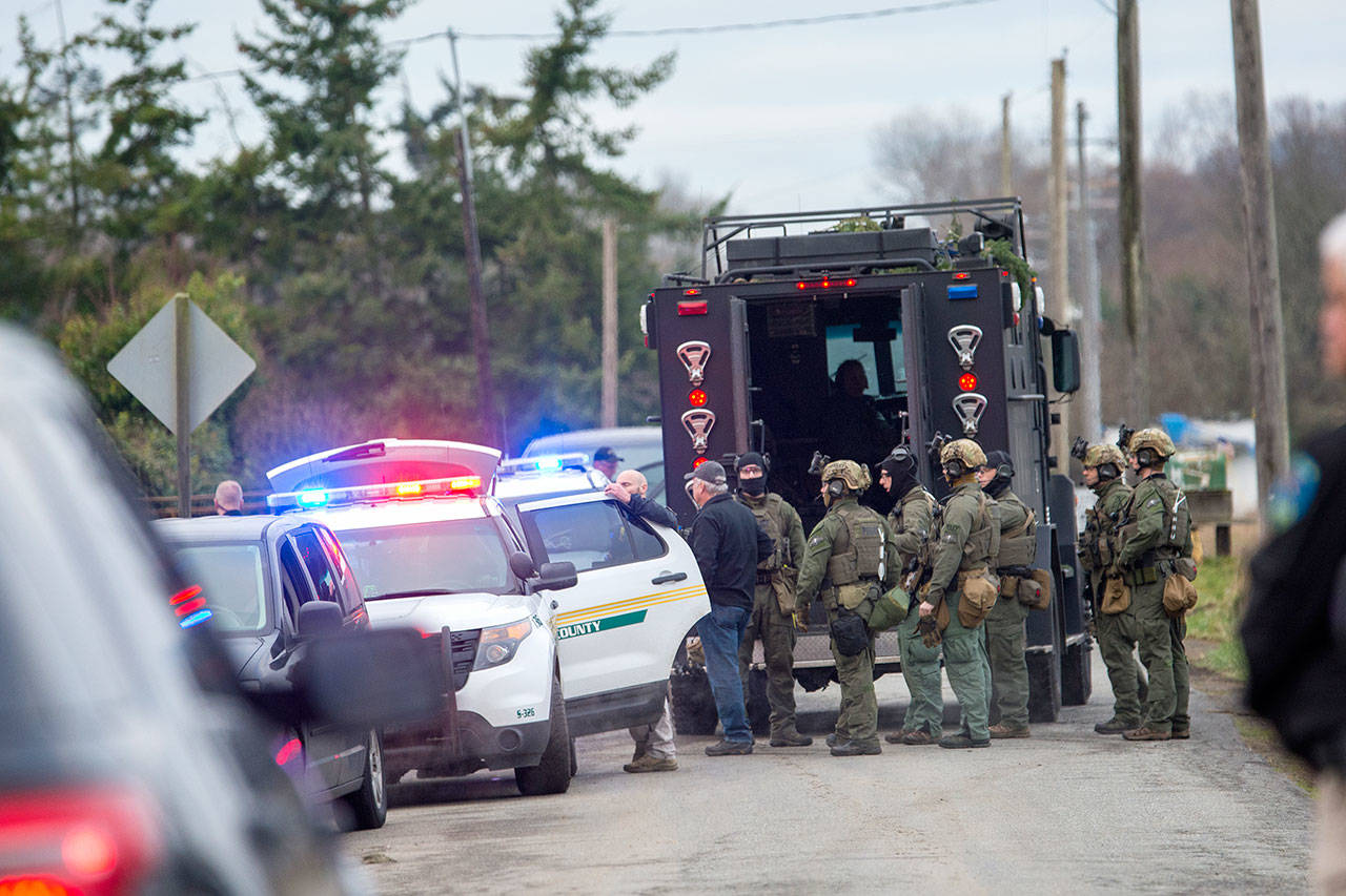 The State Patrol SWAT team gathers after serving a warrant Thursday morning that led to the arrest of a man suspected to be involved in the triple homicide discovered New Years Eve. (Jesse Major/Peninsula Daily News)