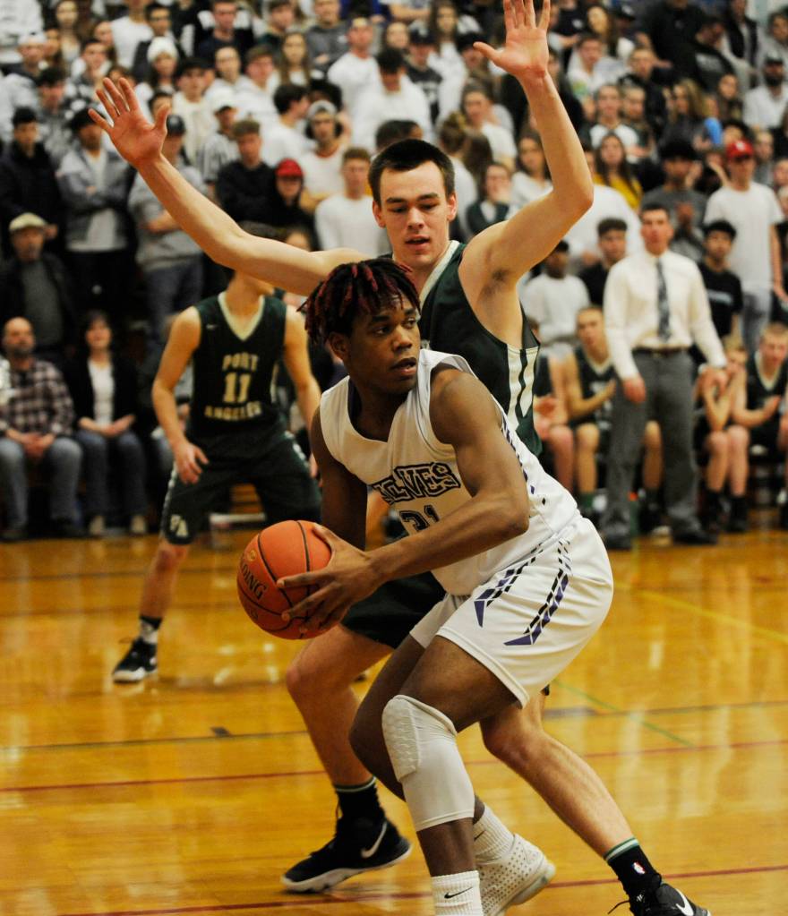 Sequims Keeshawn Whitney looks to pass as Port Angeles post Liam Clark defends in the Roughriders 63-48 win in Sequim on Jan. 31. Whitney had six points. Sequim Gazette photo by Michael Dashiell