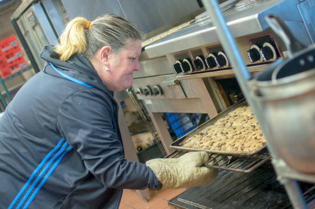 Roxann Tiller checks on the batch of cookies she is baking Thursday at Serenity House of Clallam Countys night-by-night shelter. (Jesse Major/Peninsula Daily News)