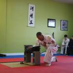 Larry Muckley breaks concrete tiles to display power during his black belt testing earlier this month. He earned his 2nd degree black belt. Submitted photo