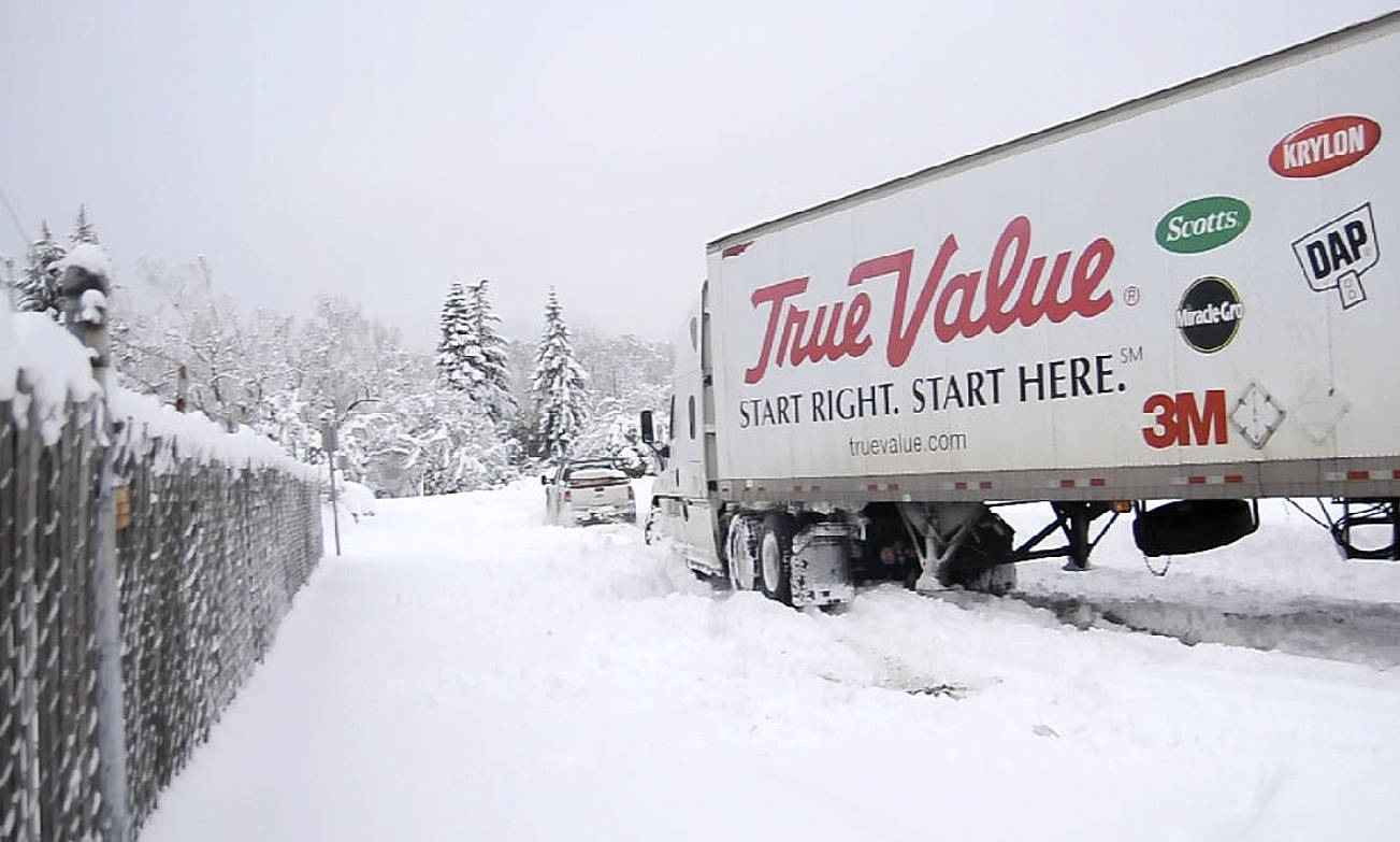 The driver of a semi making a delivery to the Clallam Co-Op gets a helping hand  and wheels from a local driver on Feb. 9. Sequim Gazette photo by Michael Dashiell
