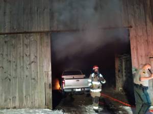 Firefighters with Clallam County Fire District 3 quickly worked to stop a truck fire from spreading to a historic barn on Old Olympic Highway on Feb. 15. Photo courtesy of Clallam County Fire District 3