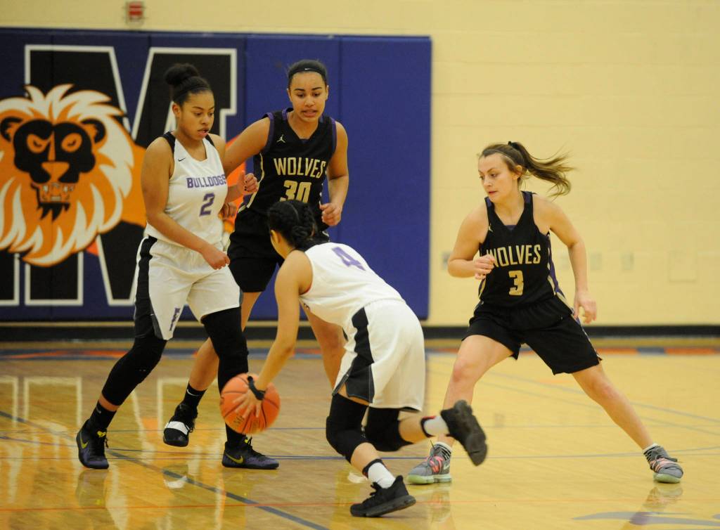 Sequims Bobbi Sparks, right, and Jayla Julmist defend Foster guard Meera Santos in the second half of the Wolves 54-44 win at regionals on Feb. 22. Sequim Gazette photo by Michael Dashiell