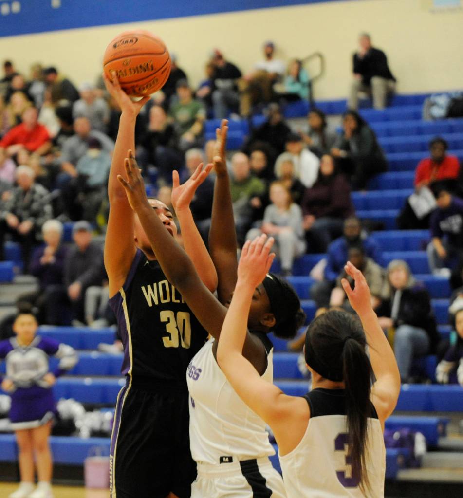 Sequim post Jayla Julmist, left, puts up a shot over Fosters Dyhani Frazier and Makanalani Montoya in the first half of Sequims win over the Bulldogs this past weekend, sending the Wolves to their fourth state tournament in school history. Julmist had nine points and 19 rebounds in the victory. Sequim Gazette photo by Michael Dashiell