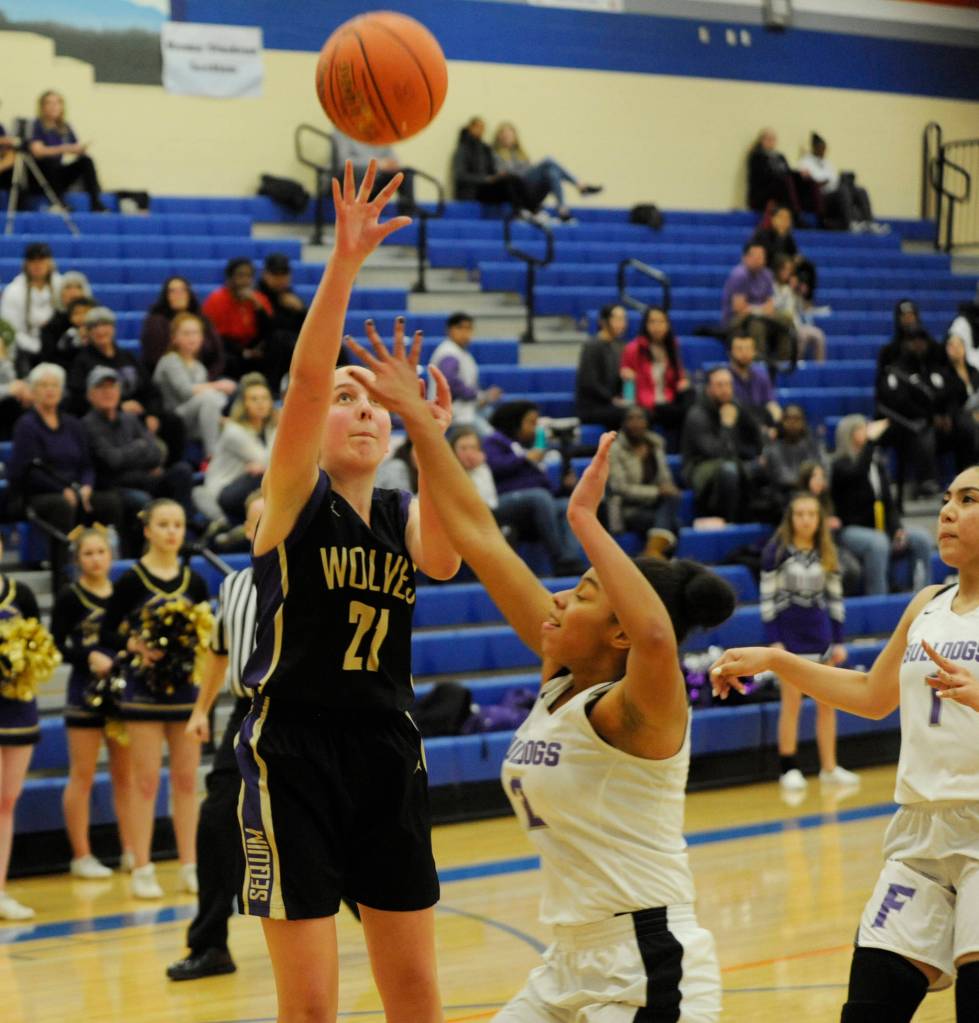Sequim sophomore Kalli Wiker shoots over Fosters Kaimyla Nolen on Feb. 22. Wiker sank a key 3-pointer late in the Wolves 54-44 win in the regional tourney. Sequim Gazette photo by Michael Dashiell