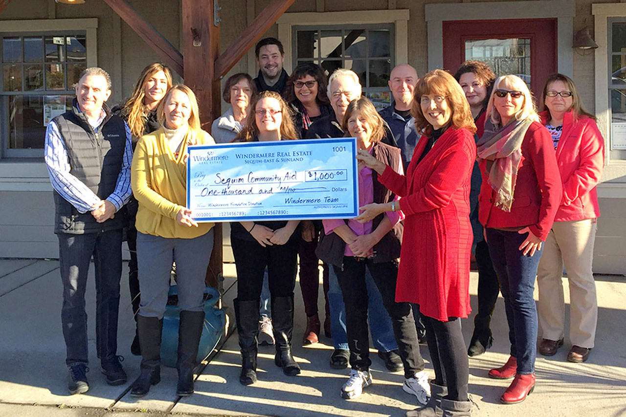 Windermere Real Estate brokers in Sequim recently donated $1,000 to Sequim Community Aid to help the local, non-profit 501(c)3, donor-based organization provide emergency financial support with rent and utilities. Pictured from left, are Alan Burwell, Kylie Walters, Marcee Medgin, Carol Dana, Jessica Warriner, Andrew Bradshaw, Dianna DaSilva, Dave Sharman, Cathy Reed, Joel Miller, Kathy Suta, president of Sequim Community Aid, Dollie Sparks, Jody McLean, and Sheryl Payseno Burley. Photo courtesy of Windermere Sequim