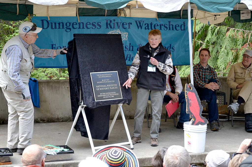 At the 2015 Dungeness River Festival, Clare Manis-Hatler and Ken Wiersema unveil a plaque certifying that the Dungeness River Railroad Bridge was placed on the National Register of Historic Places by the U.S. Department of the Interior. Its been registered since 1982 but Dungeness River Center supporters like Manis-Hatler wanted to make note of it for the bridges 100th anniversary. Sequim Gazette file photo by Matthew Nash