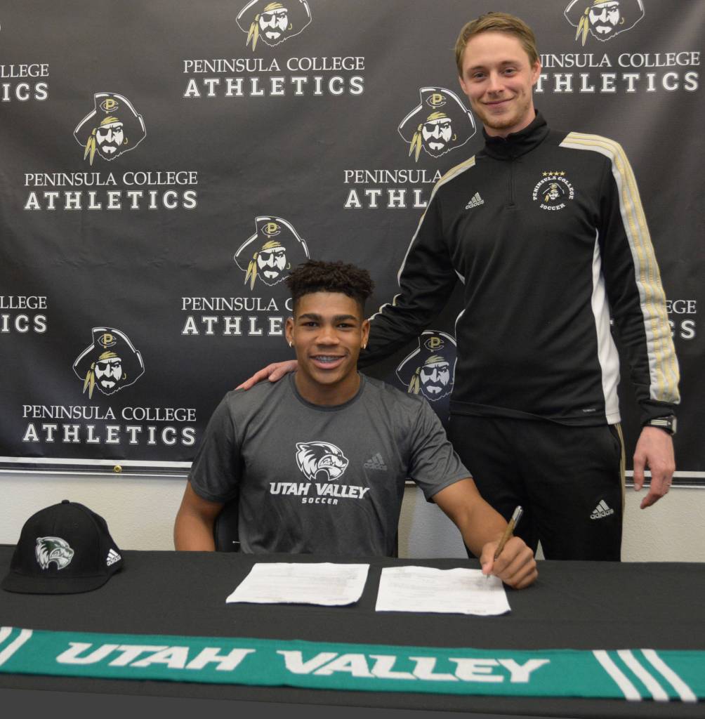 Sterling Penniston-John, left, signs a national letter of intent last week to play at Division I Utah Valley State University. The two-time Northwest Athletic Conference All-Star at Peninsula College is joined here by PC mens head coach Jake Hughes. Photo courtesy of Peninsula College