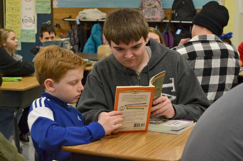 Harrison Kuh, a third grader in Ann Riggs class, reads to Sequim High schooler Hunter Walters on March 1 for Read Across America Day. Sequim Gazette photo by Matthew Nash