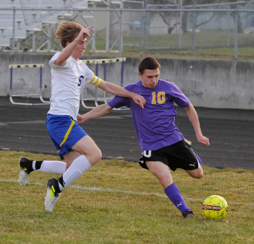 Sequims Mathys Tanche, right, looks to slip the ball past Bremerton defender Ian Stuart. Sequim Gazette photo by Michael Dashiell