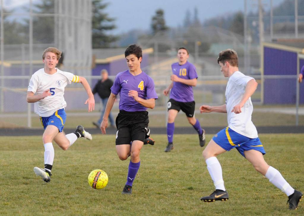 Sequims Sean Weber, center, dribbles through the Bremerton defense in the first half. Sequim Gazette photo by Michael Dashiell