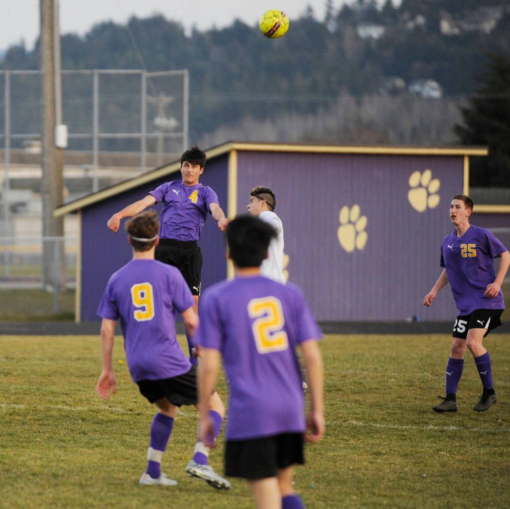 Sequims Sean Weber (4) heads the ball in the first half. Sequim Gazette photo by Michael Dashiell