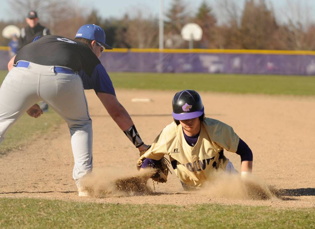 Sequims Michael Young dives back to first base in the Wolves March 20 win over North Mason. Sequim Gazette photo by Michael Dashiell