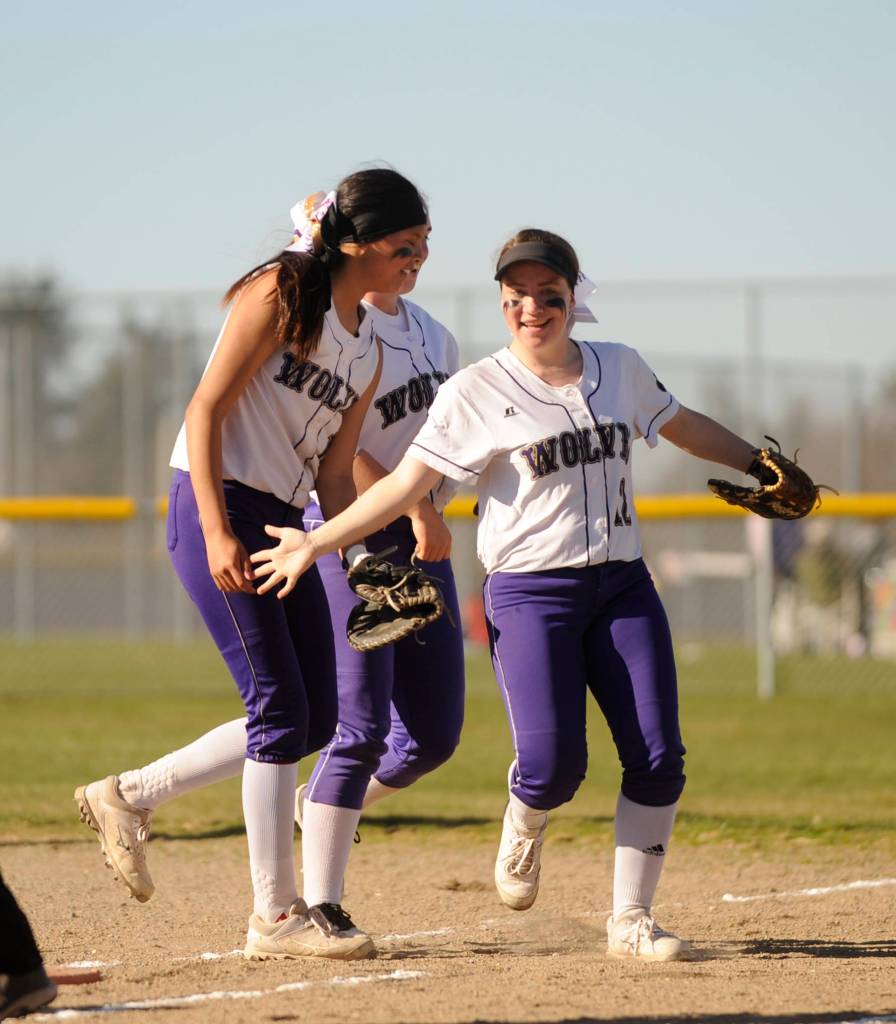 SHS outfielder Madison Nute, right, gets high-fives from teammates and coaches after helping record a double play in the Wolves 9-2 win against North Mason last week. Sequim Gazette photo by Michael Dashiell