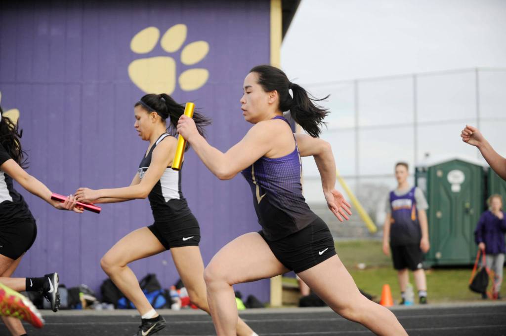 Sequim junior Lesea Pfeffer takes the baton in the second leg of the 4x100 relay on March 21. Sequims team of Shayli Schuman, Mary McAleer, Abby Schroeder and Pfeffer won the event. Sequim Gazette photo by Michael Dashiell