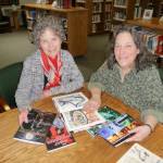 Tribal librarian Bonnie Roos, left, and Betty Oppenheimer, tribal communications specialist, display part of the librarys collection of graphic novels designed by Native American artists. Sequim Gazette photo by Patricia Morrison Coate