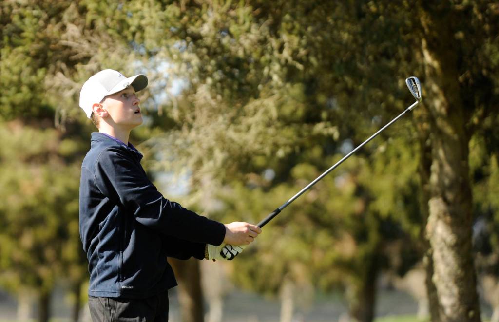 Dominic Riccobene watches a drive on the 11th hole at The Cedars at Dungeness on March 26. The freshman shot a nine-hole round of 45 as the Wolves topped Kingston by 52 shots. Sequim Gazette photo by Michael Dashiell