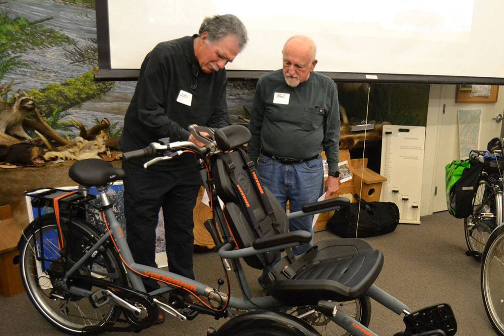 Joel McGehee, left, and Ron Adler, both of Sequim, look at the newest bicycle for the Sequim Wheelers program. Organizers plan to start giving rides in late April/early May for around four months. Sequim Gazette photo by Matthew Nash