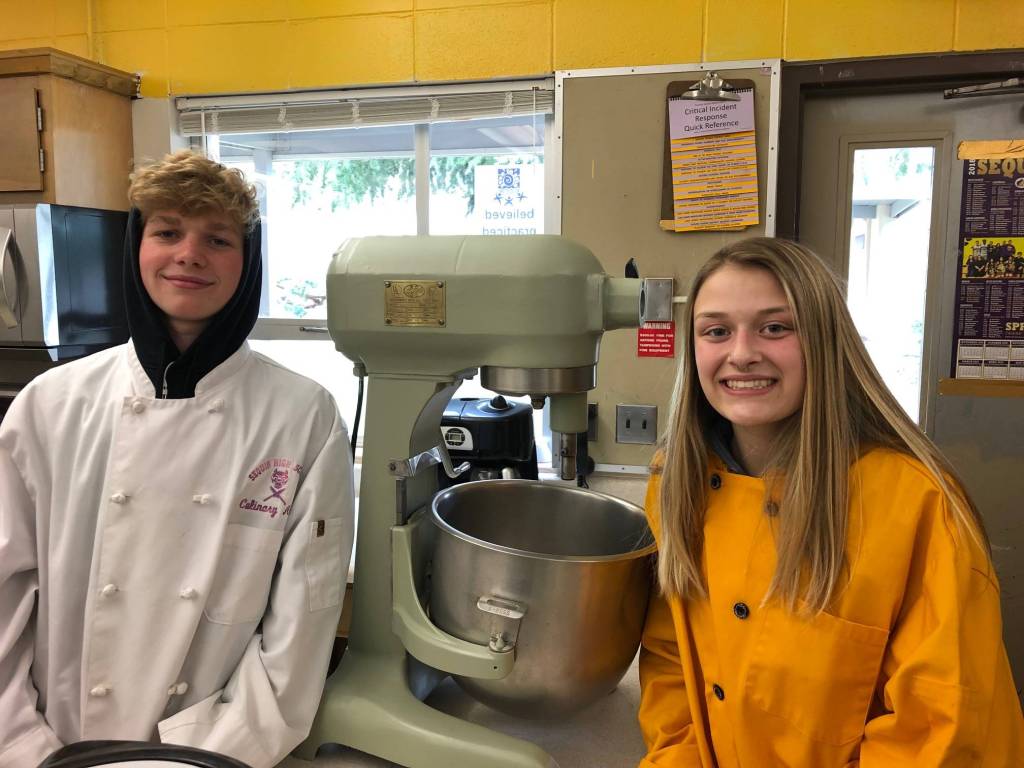 Sequim High students Marcus Allen and Emily Dodson stand next to a newly donated Hobart mixer. Photo by Tyler Fritz