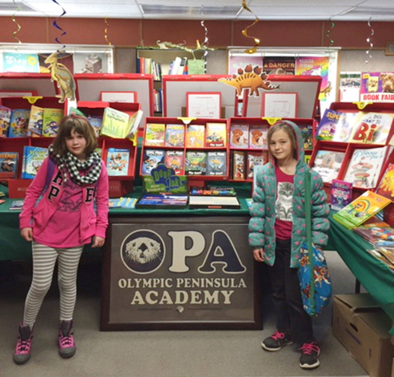 Olympic Peninsula Academy second-graders Gabby Terry and Josephine Johnson take part in OPAs Scholastic Book Fair. Submitted photo