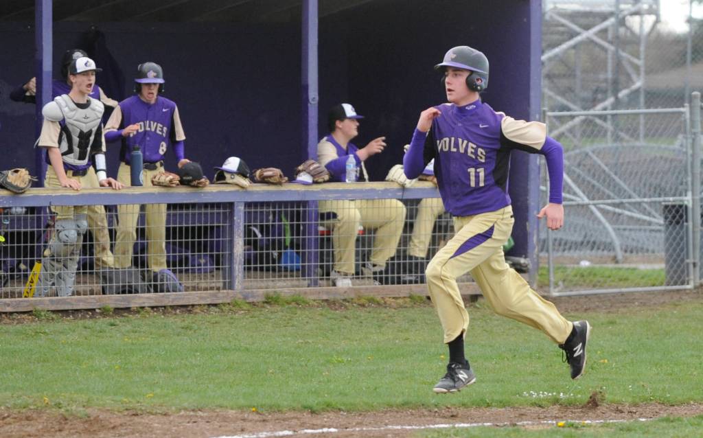 Sequim sophomore Austin Newton comes in to score in a seven-run fourth inning against the Olympic Trojans. Sequim Gazette photo by Michael Dashiell