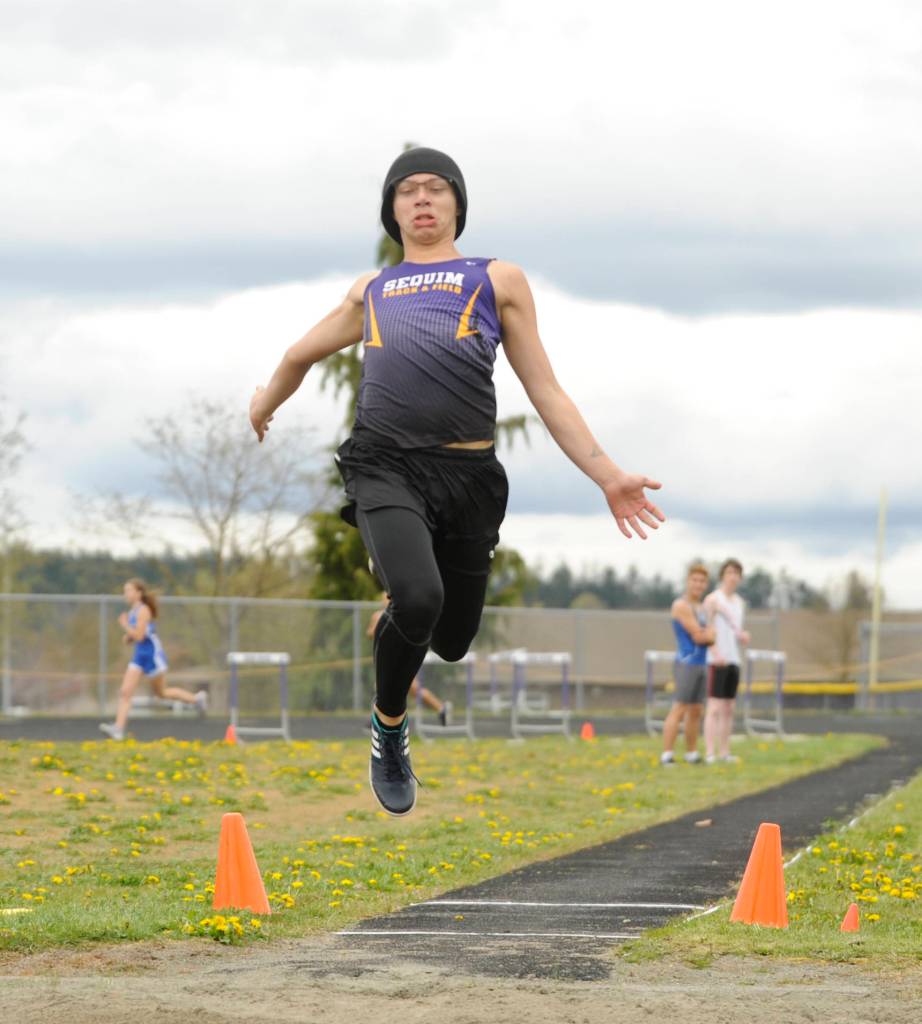 Sequim High senior Richard Hall leaps to a 17-foot, 5-inch mark in the long jump, taking first place at an Olympic League meet in Sequim on April 11. Sequim Gazette photo by Michael Dashiell